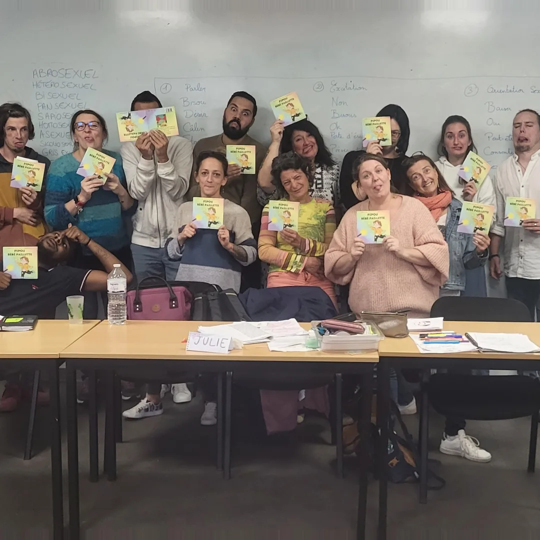 Un groupe en formation VASE brandissant le livre Pipou, bébé paillette